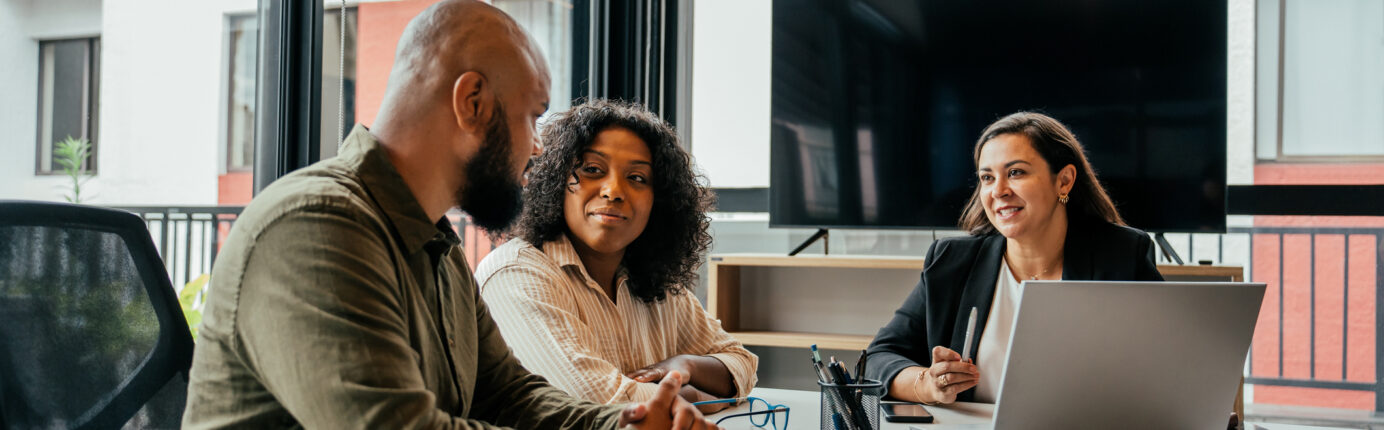 Couple talking to real estate agent in office